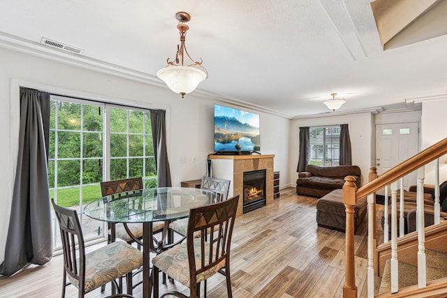 21113 Clydesdale Curv, Forest Lake, MN 55025 - dining space with a tile fireplace, light wood-type flooring, ornamental molding, and stairway