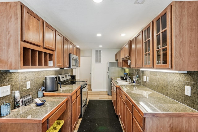 21113 Clydesdale Curv, Forest Lake, MN 55025 - kitchen with stainless steel appliances, tile counters, brown cabinets, and recessed lighting