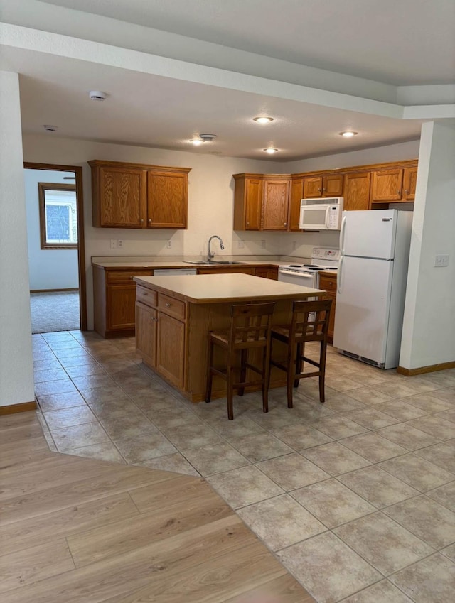 1432 Tall Grass, Hudson, WI 54016 - kitchen with white appliances, brown cabinetry, a center island, light countertops, and a sink