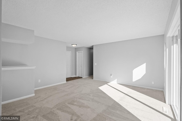 230 8th St NW, Elk River, MN 55330 - unfurnished living room featuring a textured ceiling, carpet flooring, and baseboards