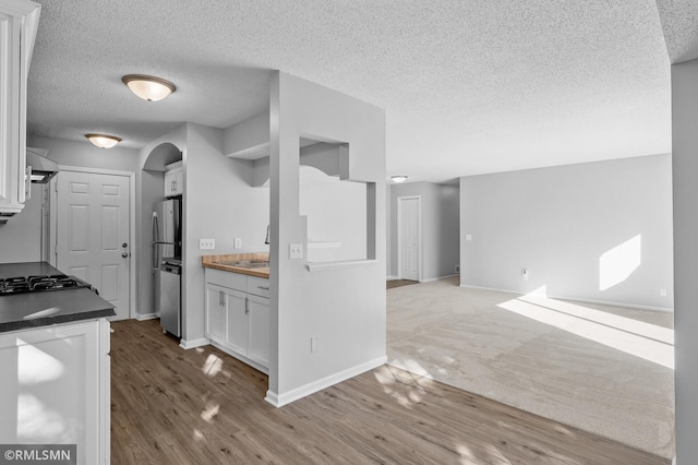 230 8th St NW, Elk River, MN 55330 - kitchen with white cabinets, wood finished floors, a textured ceiling, and open floor plan