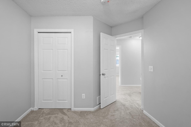 230 8th St NW, Elk River, MN 55330 - unfurnished bedroom with a textured ceiling, carpet floors, a closet, and baseboards