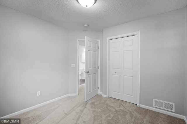 230 8th St NW, Elk River, MN 55330 - unfurnished bedroom featuring a textured ceiling, a closet, carpet, and baseboards