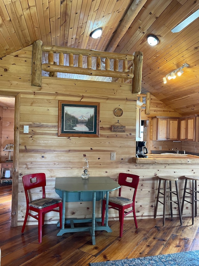 dining area with lofted ceiling, wooden walls, hardwood / wood-style floors, and wood ceiling