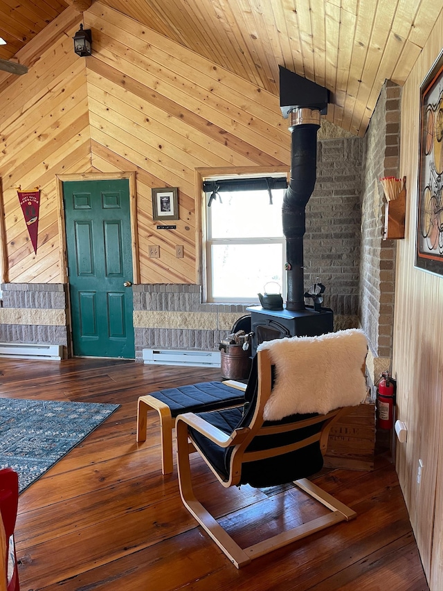 living area featuring wood walls, hardwood / wood-style floors, wood ceiling, a baseboard radiator, and a wood stove