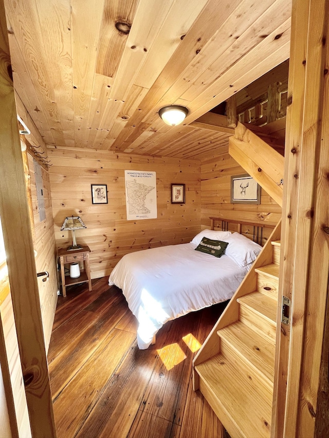 bedroom with wood ceiling, wood-type flooring, and wood walls