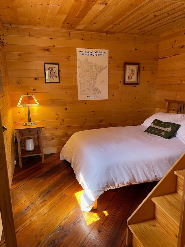 bedroom with wooden walls, wooden ceiling, and wood-type flooring