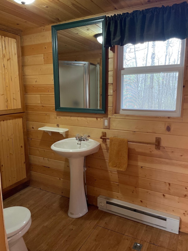 full bathroom with baseboard heating, a stall shower, wood walls, wood finished floors, and wooden ceiling