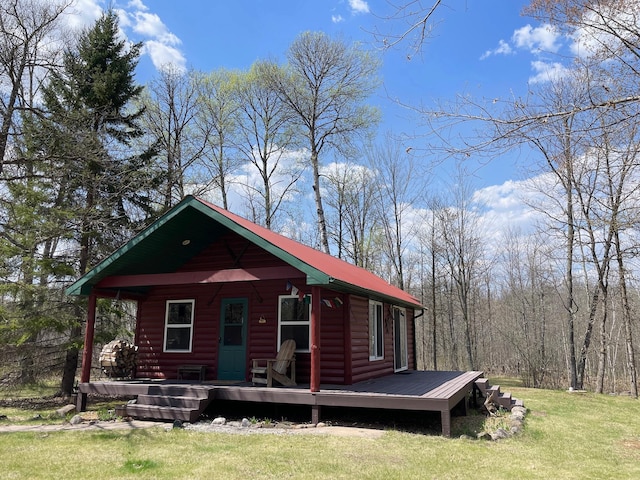 view of front of property with log veneer siding, a front lawn, and covered porch