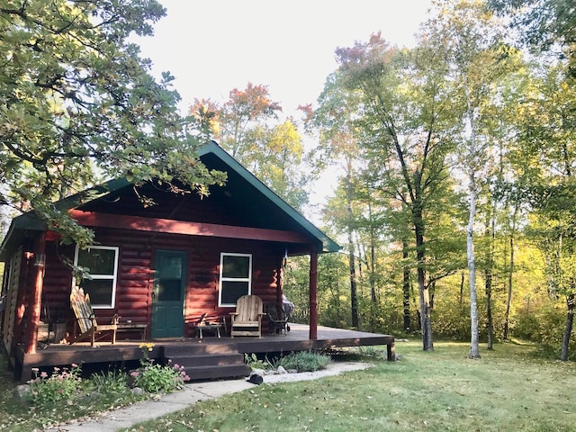 log home featuring a front lawn and covered porch