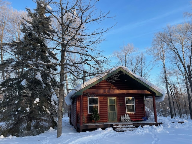 snow covered structure with a porch
