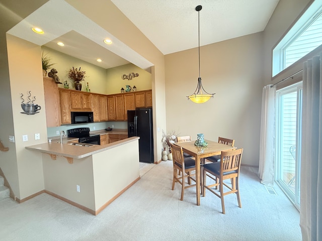 5173 Farnham Dr N, Hugo, MN 55038 - kitchen with black appliances, light colored carpet, a peninsula, recessed lighting, and a towering ceiling