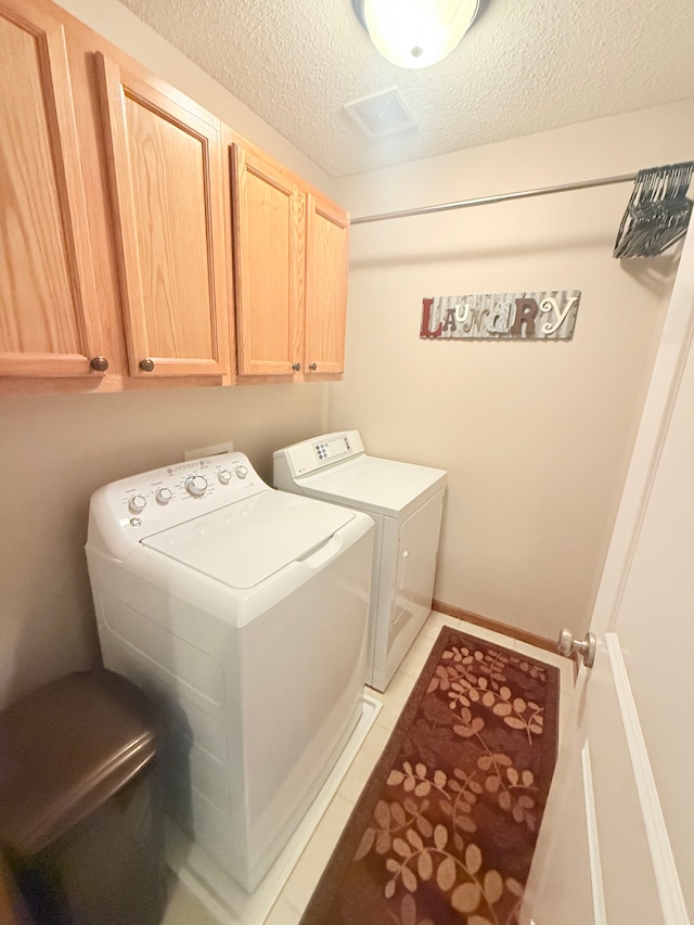 5173 Farnham Dr N, Hugo, MN 55038 - clothes washing area featuring cabinet space, independent washer and dryer, a textured ceiling, and light tile patterned flooring