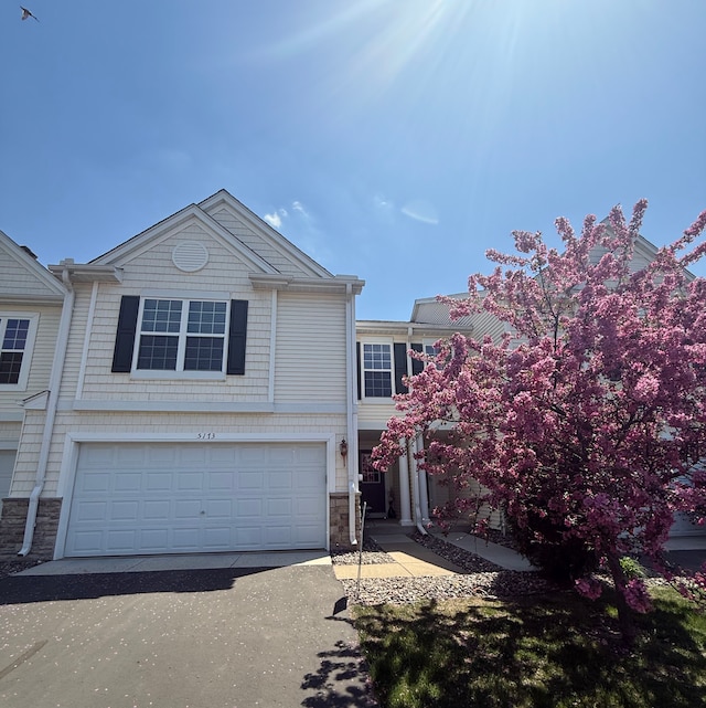 5173 Farnham Dr N, Hugo, MN 55038 - townhome / multi-family property with stone siding, a garage, and asphalt driveway