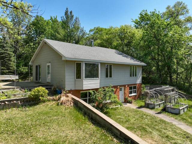 1286 Krattley Ln, North Hudson, WI 54016 - view of home's exterior featuring a garden, a lawn, and a shingled roof