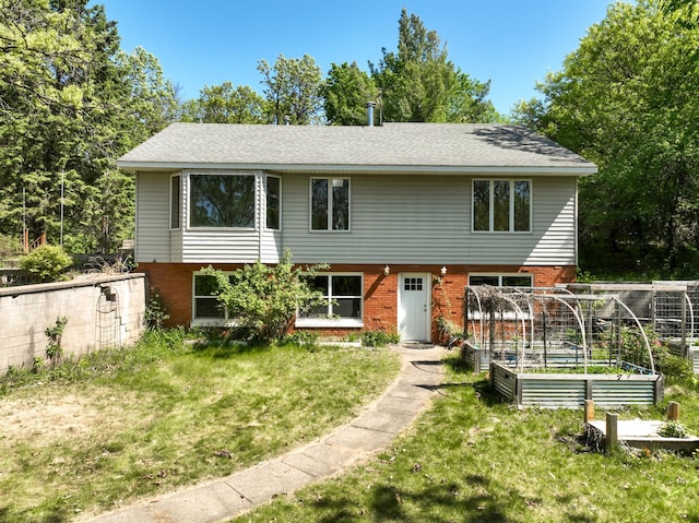 1286 Krattley Ln, North Hudson, WI 54016 - view of front of house with a vegetable garden, a front lawn, and brick siding