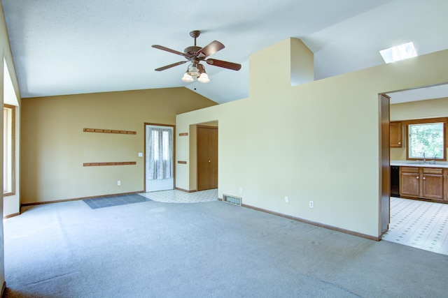1286 Krattley Ln, North Hudson, WI 54016 - unfurnished living room featuring light colored carpet, baseboards, ceiling fan, high vaulted ceiling, and a sink