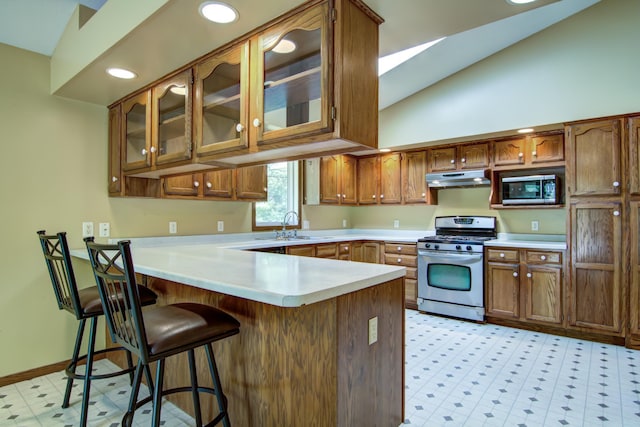 1286 Krattley Ln, North Hudson, WI 54016 - kitchen with appliances with stainless steel finishes, under cabinet range hood, a peninsula, brown cabinets, and light countertops