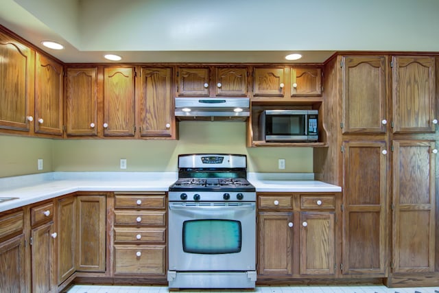 1286 Krattley Ln, North Hudson, WI 54016 - kitchen featuring appliances with stainless steel finishes, under cabinet range hood, brown cabinetry, light countertops, and recessed lighting