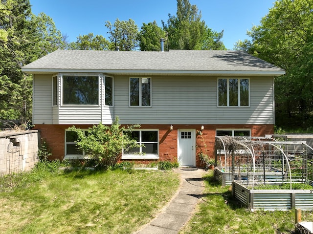 1286 Krattley Ln, North Hudson, WI 54016 - view of front facade featuring a garden, a front yard, and brick siding