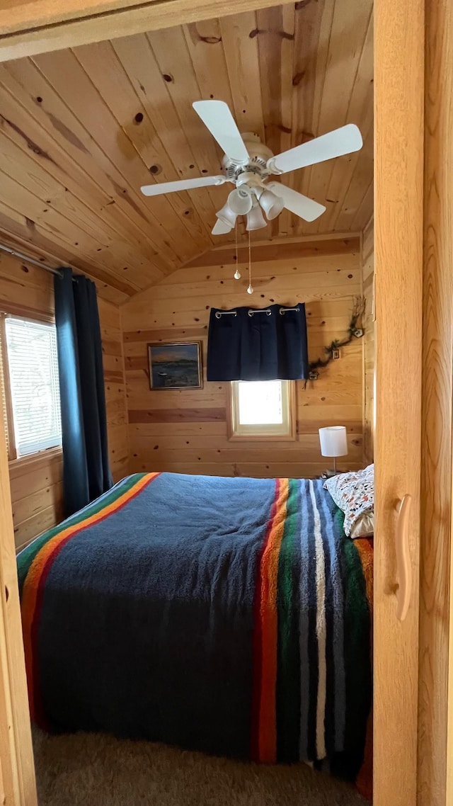 bedroom featuring wood ceiling, wooden walls, vaulted ceiling, and ceiling fan
