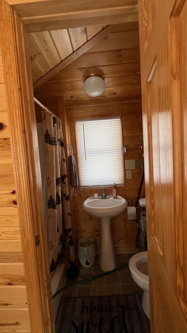bathroom with toilet, tile patterned floors, a shower with curtain, wood walls, and wooden ceiling