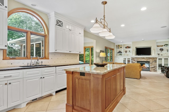 11600 43rd Ave N, Plymouth, MN 55442 - kitchen featuring a sink, a fireplace, a kitchen island, dark stone countertops, and light tile patterned floors