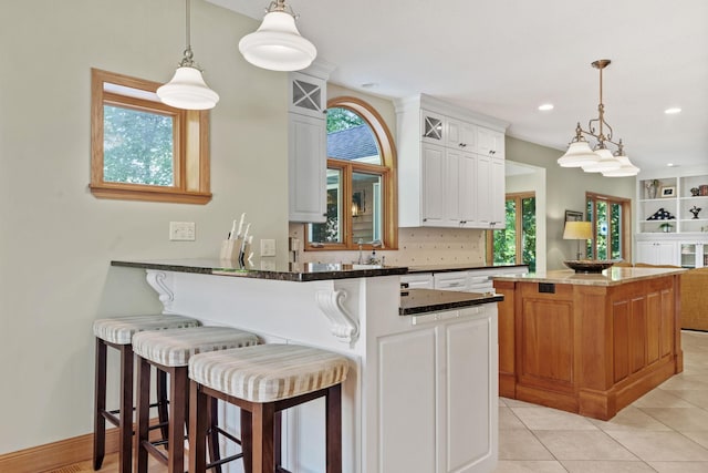 11600 43rd Ave N, Plymouth, MN 55442 - kitchen featuring white cabinets, pendant lighting, a kitchen island, a kitchen breakfast bar, and a peninsula