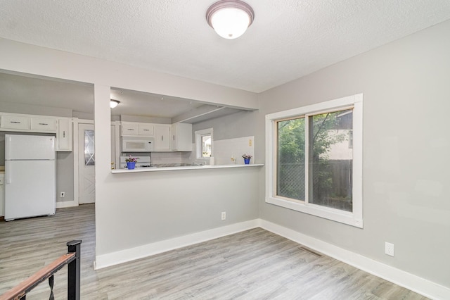 476 Brainerd Ave, Saint Paul, MN 55130 - kitchen with white appliances, white cabinets, light wood-type flooring, baseboards, and a textured ceiling