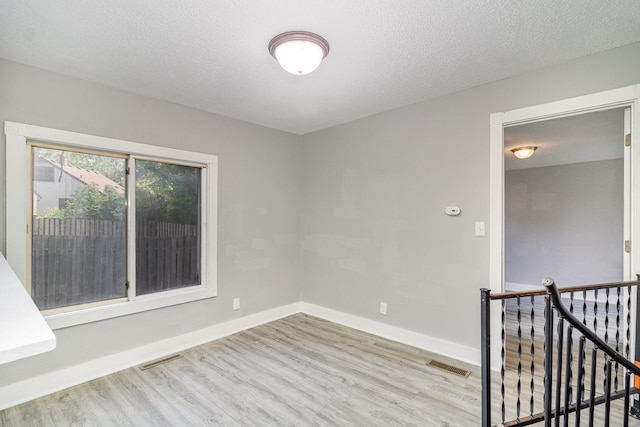 476 Brainerd Ave, Saint Paul, MN 55130 - unfurnished room featuring wood finished floors, baseboards, and a textured ceiling
