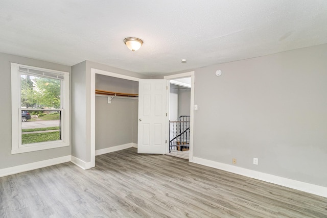 476 Brainerd Ave, Saint Paul, MN 55130 - unfurnished bedroom featuring baseboards, wood finished floors, and a closet