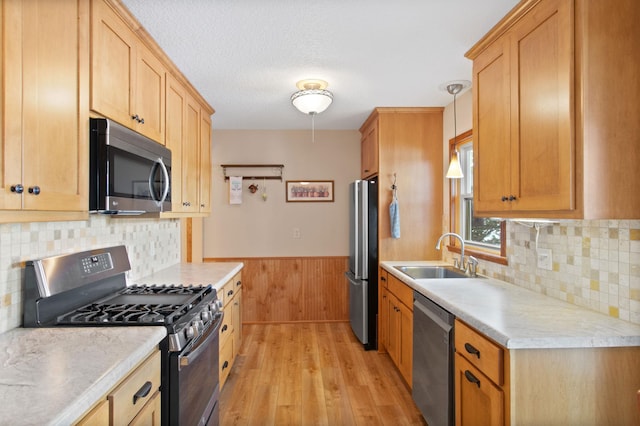 12177 Fremont Ln, Zimmerman, MN 55398 - kitchen featuring stainless steel appliances, light wood-type flooring, light countertops, a wainscoted wall, and wood walls