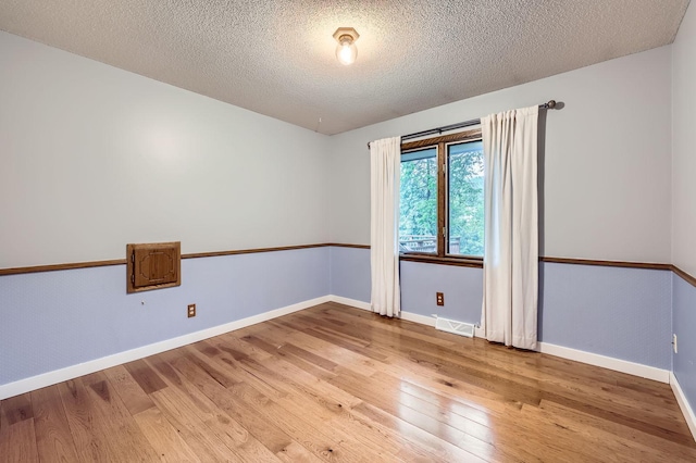 11476 65th Pl N, Maple Grove, MN 55369 - empty room with hardwood / wood-style flooring, a textured ceiling, and baseboards