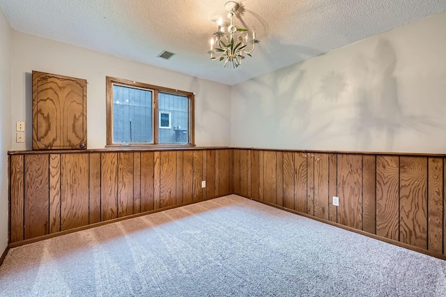 11476 65th Pl N, Maple Grove, MN 55369 - carpeted spare room featuring a textured ceiling, a chandelier, a wainscoted wall, and wooden walls