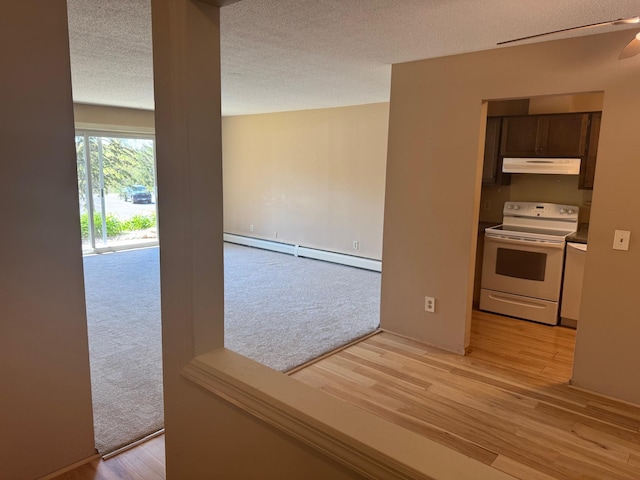 unfurnished room featuring baseboard heating, light wood-style floors, ceiling fan, and a textured ceiling