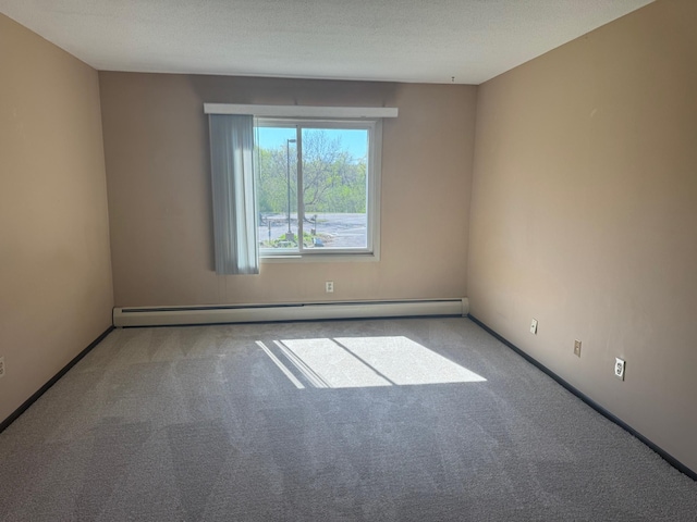 carpeted empty room with baseboard heating and baseboards