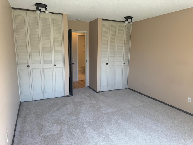 unfurnished bedroom featuring multiple closets and carpet