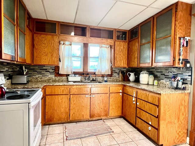 308 Cedar Ave S, Odessa, MN 56276 - kitchen with electric stove, a sink, backsplash, and brown cabinets