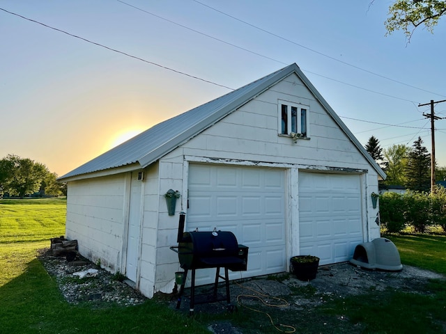 308 Cedar Ave S, Odessa, MN 56276 - garage at dusk featuring a detached garage and a lawn