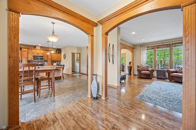 15350 Blackhawk Rd, Audubon, MN 56511 - living room with arched walkways, baseboards, recessed lighting, decorative columns, and light wood-style flooring