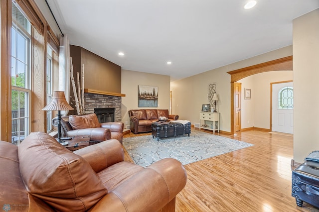 15350 Blackhawk Rd, Audubon, MN 56511 - living room featuring light wood-style flooring, a fireplace, recessed lighting, arched walkways, and baseboards