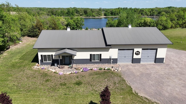 13936 County Road 7 NW, Clearwater Twp, MN 55320 - view of front facade featuring a garage, asphalt driveway, metal roof, a front lawn, and a wooded view
