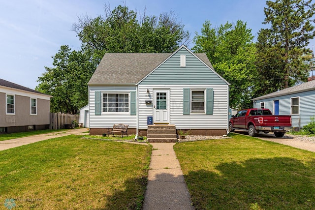 1538 10th St N, Fargo, ND 58102 - view of front of house featuring a front lawn, roof with shingles, and driveway