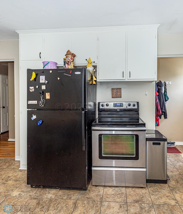 1538 10th St N, Fargo, ND 58102 - kitchen featuring freestanding refrigerator, stainless steel range with electric cooktop, white cabinets, and baseboards