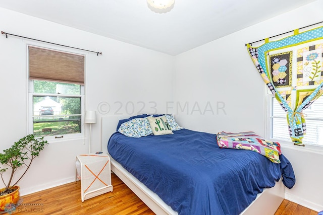 1538 10th St N, Fargo, ND 58102 - bedroom with wood finished floors, multiple windows, and baseboards