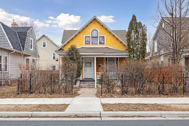 3205 Grand Ave S, Minneapolis, MN 55408 - view of front of house featuring a porch, a fenced front yard, stucco siding, and roof with shingles
