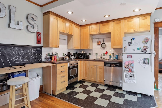 3205 Grand Ave S, Minneapolis, MN 55408 - kitchen featuring appliances with stainless steel finishes, dark flooring, dark countertops, crown molding, and decorative backsplash