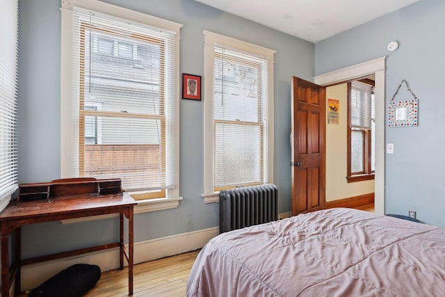 3205 Grand Ave S, Minneapolis, MN 55408 - bedroom with radiator heating unit, wood finished floors, multiple windows, and baseboards