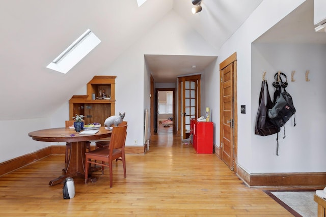 3205 Grand Ave S, Minneapolis, MN 55408 - dining room with a skylight, lofted ceiling, light wood-style floors, and baseboards