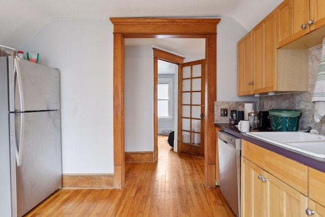 3205 Grand Ave S, Minneapolis, MN 55408 - kitchen with appliances with stainless steel finishes, lofted ceiling, light wood-style floors, tasteful backsplash, and french doors
